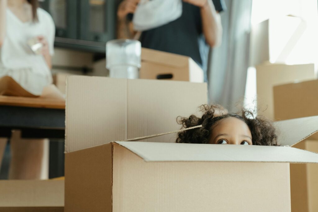 girl peeking out of moving box