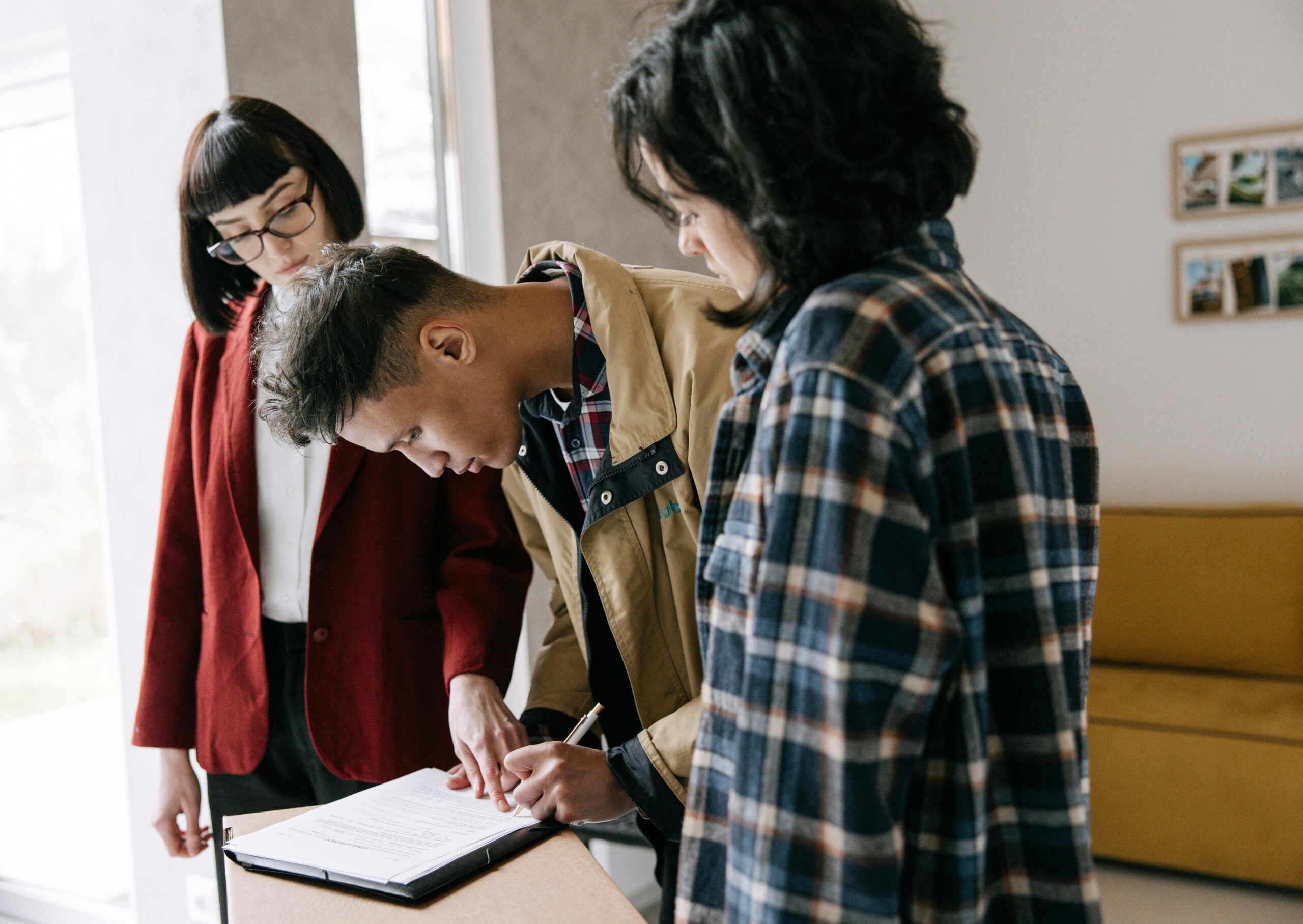 couple with real estate agent, signing document